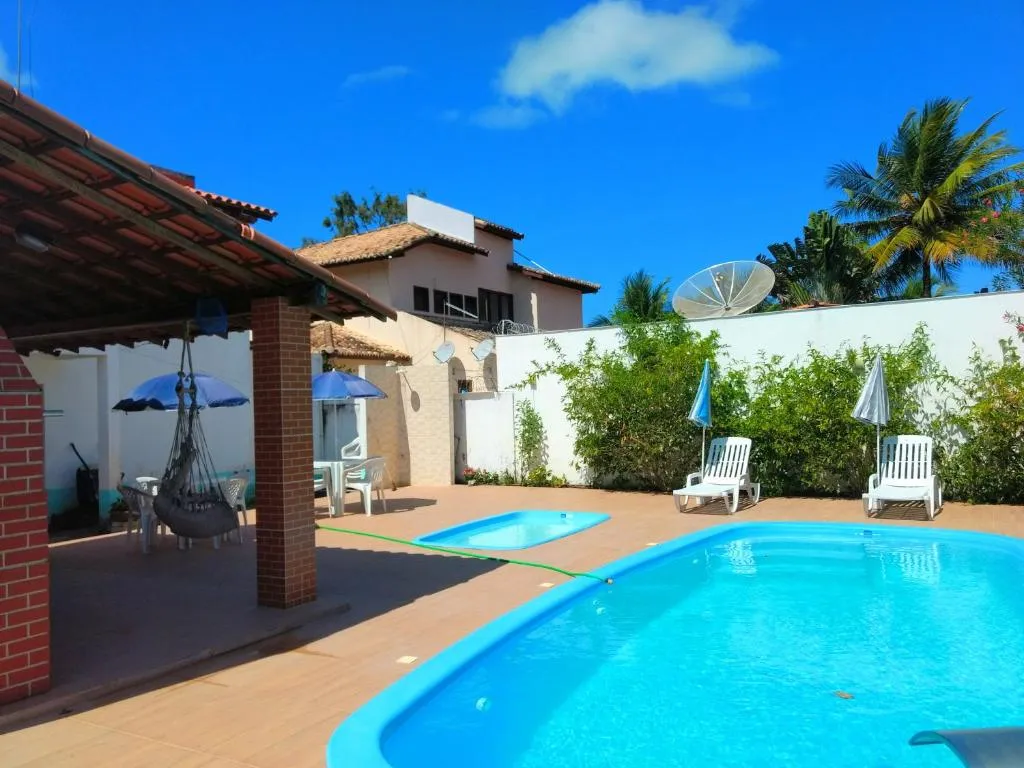 Piscina principal com deck e coqueiros