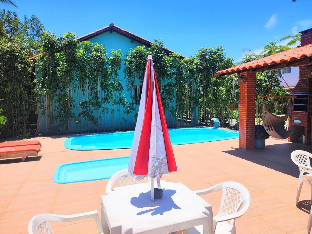 Piscina com área de descanso e guarda-sol